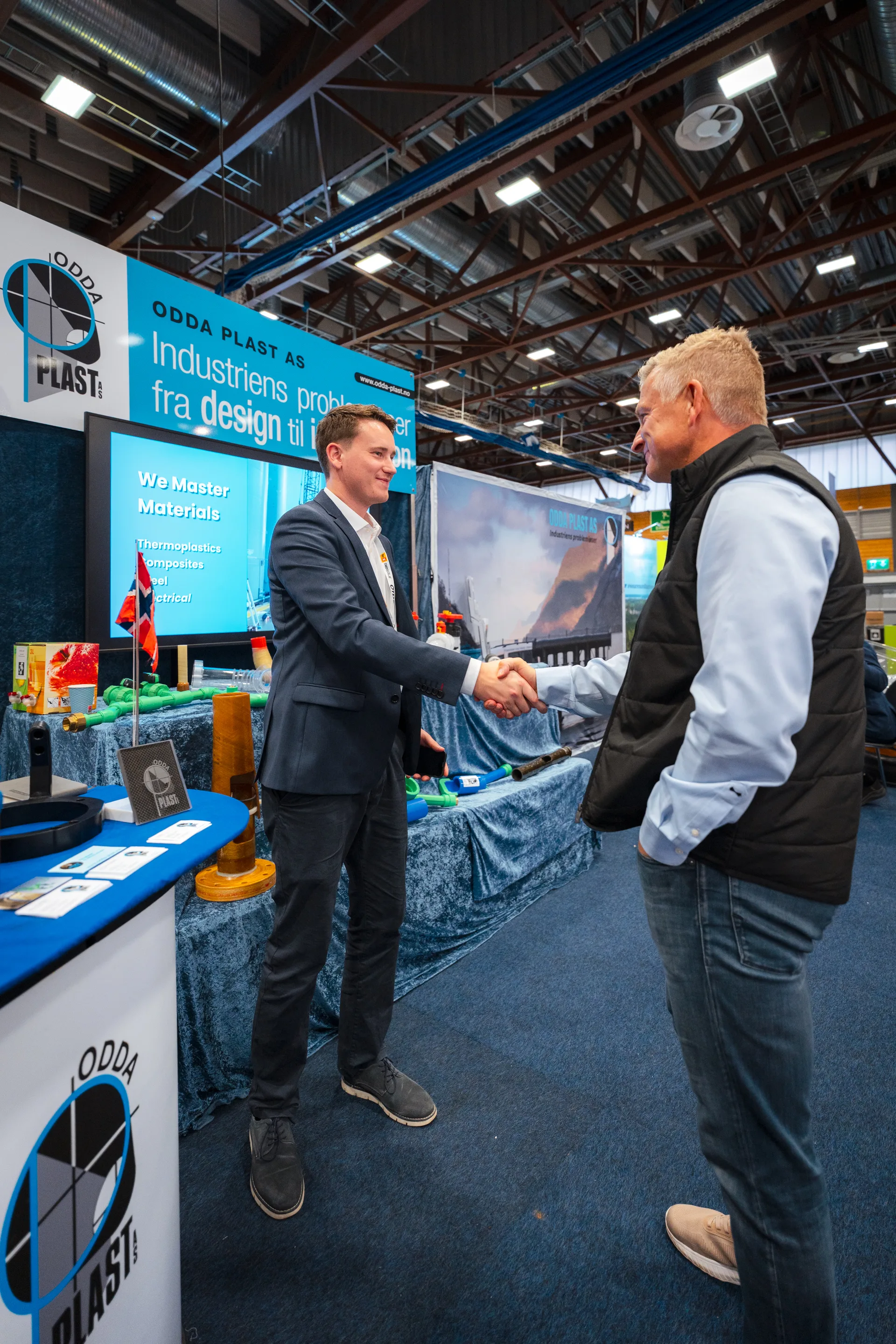 Two professionals shaking hands at an OTD Energy 2025 exhibitor stand